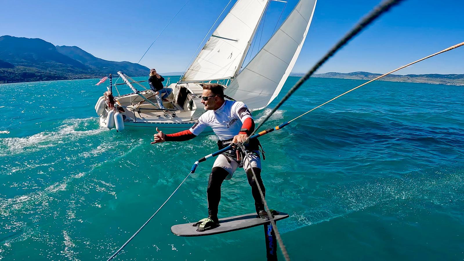 Un rider en kitefoil passe devant un voilier sur le L&eacute;man